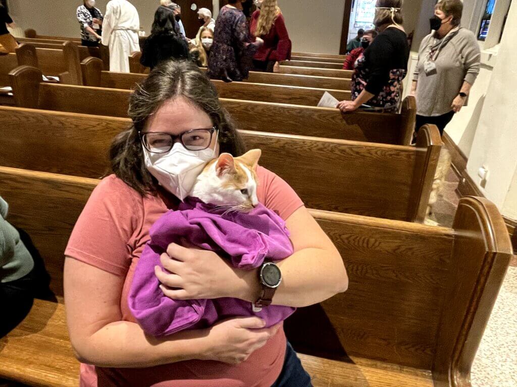 Parishioner holding cat for animal blessing