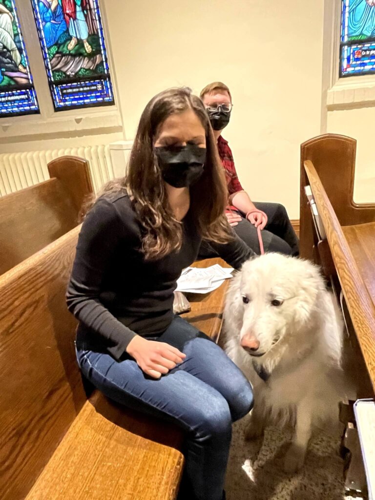 Two parishioners with dog in pew